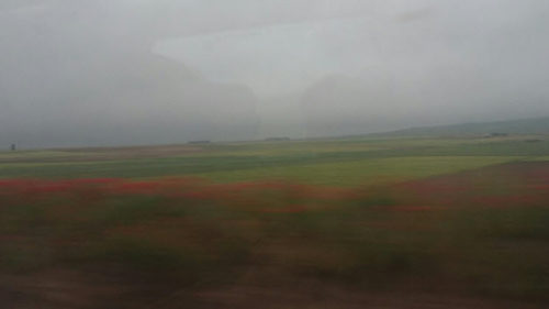 Photo taken from a train of the rain in Spain falling mainly on the plain.