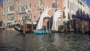 Lorenzo Quinn's "Suppport" sculpture rising out of the waters of the Grand Canal in Venice.